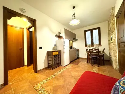 a kitchen with a white refrigerator and a table at Casale Orioles in Torretta