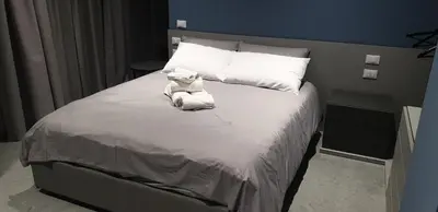 a white teddy bear sitting on top of a bed at Granatelli Rooms in Palermo