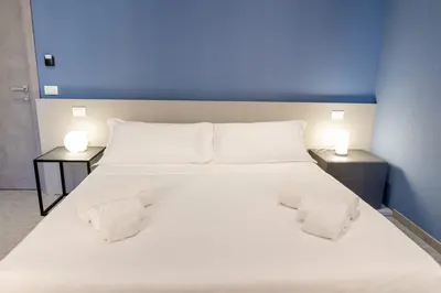 a large white bed with two nightstands and two lamps at Granatelli Rooms in Palermo