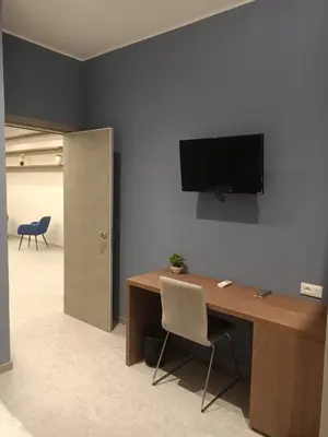 an office with a desk with a television on the wall at Granatelli Rooms in Palermo