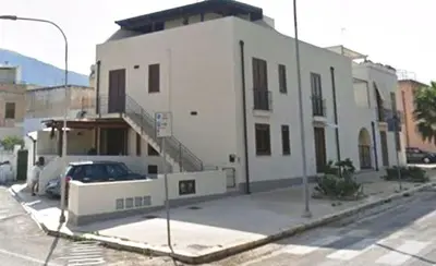 a white building with a car parked in front of it at CASE COLOMBO E MATTARELLA by Trerose Properties - Appartamenti centrali con wi-fi e posto auto privato gratuito in San Vito lo Capo