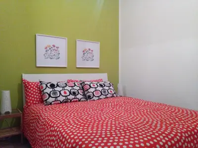 a bedroom with a bed with a red comforter at CASE COLOMBO E MATTARELLA by Trerose Properties - Appartamenti centrali con wi-fi e posto auto privato gratuito in San Vito lo Capo