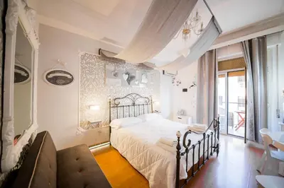 a bedroom with a white bed and a couch at Casale D' Or in Palermo