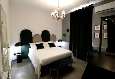 a bedroom with a white bed and a chandelier at Le stanze di Bianca in Palermo