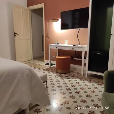 a bedroom with a bed and a desk with a television at Le stanze di Bianca in Palermo
