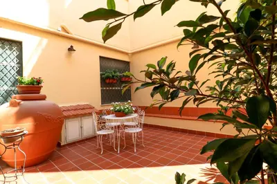 a patio with chairs and a table and a vase at Le stanze di Bianca in Palermo