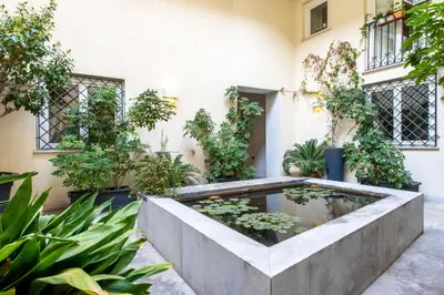 a garden with a pond in the middle of a building at Moncada Suites & Apartments in Palermo