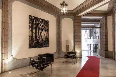 a hallway with chairs and a painting on the wall at Moncada Suites & Apartments in Palermo