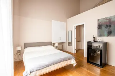 a white bedroom with a bed and a fireplace at Moncada Suites & Apartments in Palermo