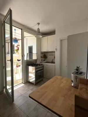 a living room with a kitchen with a table at casa magoo in Palermo