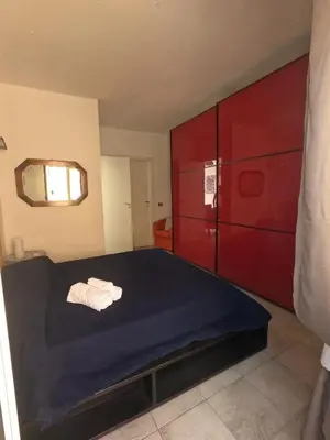 a bedroom with a bed and a red cabinet at casa magoo in Palermo