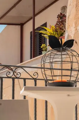 a bird cage on a table with a plant in it at casa magoo in Palermo