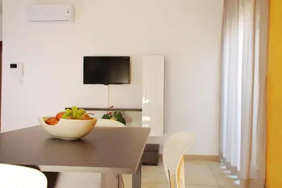 a dining room with a table with a bowl of fruit on it at Case Vacanze Anni 20 in Bagheria