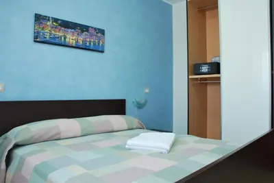 a bedroom with a bed with a blue wall at Case Vacanze Anni 20 in Bagheria