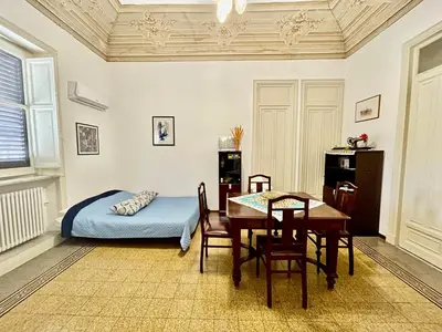 a bedroom with a table and a bed and a table and chairs at Suite Dreams Politeama in Palermo