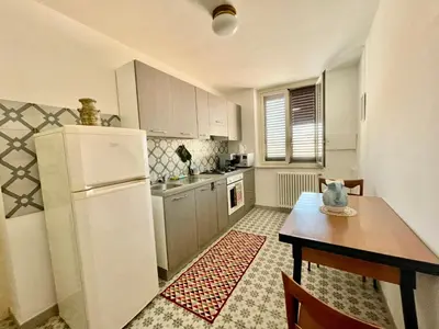 a kitchen with a table and a refrigerator at Suite Dreams Politeama in Palermo