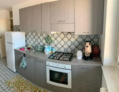 a small kitchen with a stove and a refrigerator at Suite Dreams Politeama in Palermo