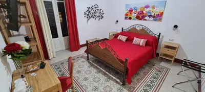 a bedroom with a bed with a red blanket at Ballarò Guest House in Palermo