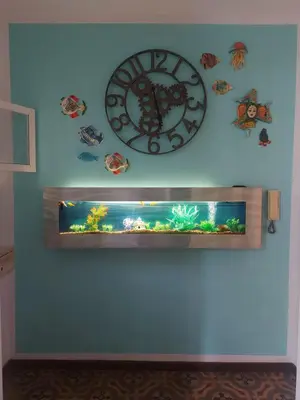 a large clock on a wall with a fish tank at LE VELE in Palermo