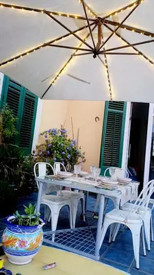 a white table and chairs under an umbrella at LE VELE in Palermo