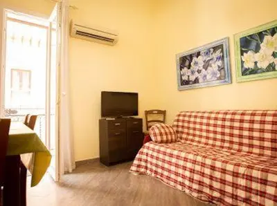 a living room with a couch and a tv at Sciabika Edificio Flowers in Castellammare del Golfo