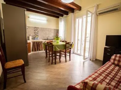 a kitchen and dining room with a table and chairs at Sciabika Edificio Flowers in Castellammare del Golfo