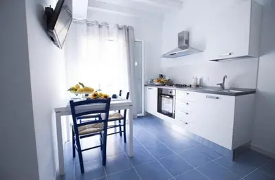 a kitchen with a table and chairs and a sink at Sciabika Edificio Flowers in Castellammare del Golfo