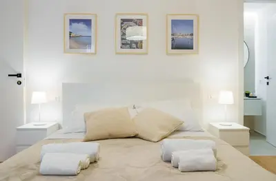 a white bedroom with a bed with two pillows at Parlamento Apartment - Esclusivo 120mq centro storico Palermo in Palermo