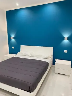 a blue bedroom with a bed with a blue wall at Vittorio Emanuele & Quattro Canti Suite Palermo in Palermo