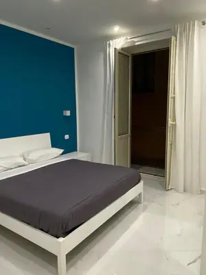 a bedroom with a bed with a blue wall at Vittorio Emanuele & Quattro Canti Suite Palermo in Palermo