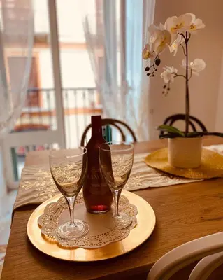 a table with a bottle of wine and two glasses at Palermo Center Residenza IN Cattedrale Superior Apartment in Palermo