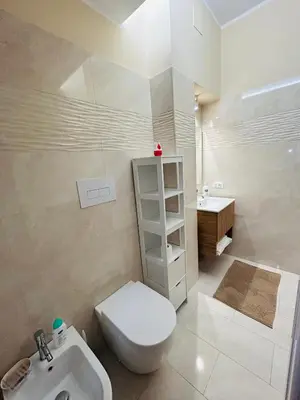 a bathroom with a white toilet and a sink at SicilyHouse Palermo in Palermo