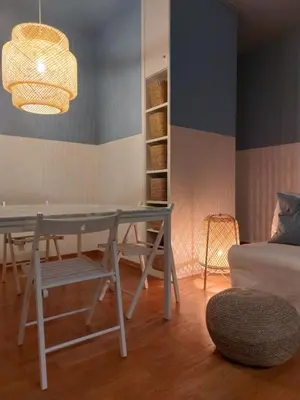 a room with a table and a bed and a lamp at Piazza Mondello Lifestyle Home Palermo in Mondello
