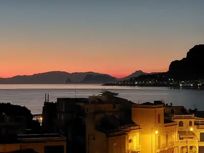 a view of the water and buildings at sunset at Piazza Mondello Lifestyle Home Palermo in Mondello