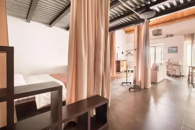 a bedroom with a bed and a living room at Tavola tonda apartament in Palermo