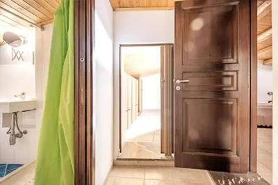 a wooden door in a bathroom with a hallway at Tavola tonda apartament in Palermo