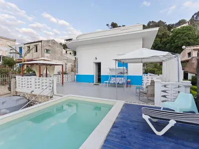 a villa with a swimming pool and a house at Seafront Apartment in Villa with Swimming Pool and Parking in Alcamo Marina