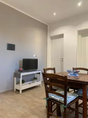 a dining room with a table and a television at San Saverio Home in Palermo