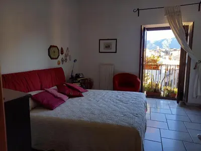 a bedroom with a bed with red pillows and a window at Panormus Cala a Mare by DomuSicily in Palermo