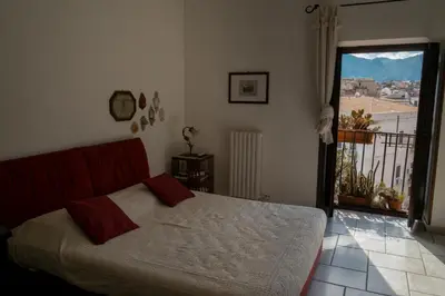 a bedroom with a bed and a large window at Panormus Cala a Mare by DomuSicily in Palermo