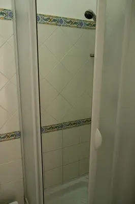 a shower with a glass door in a bathroom at Panormus Cala a Mare by DomuSicily in Palermo
