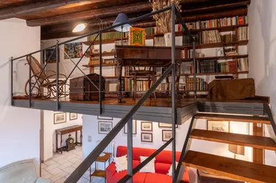a spiral staircase in a room with books at Panormus Cala a Mare by DomuSicily in Palermo