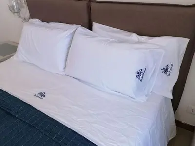 a bed with white sheets and pillows on it at Alcamo Marina Villa Pool in Alcamo Marina