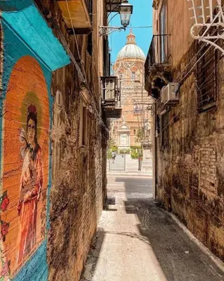 an alley with a mural on the side of a building at N'Amuri di Casa in Palermo