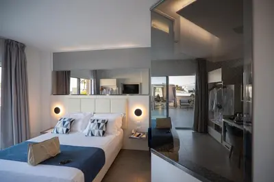 a hotel room with two beds and a bathroom at Resort La Battigia Beach & Spa in Alcamo Marina
