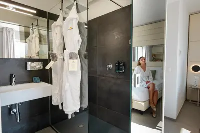 a woman sitting in a chair in a bathroom at Resort La Battigia Beach & Spa in Alcamo Marina