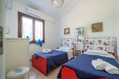 a bedroom with two beds and a window at VILLA HIBISCUS in Castellammare del Golfo