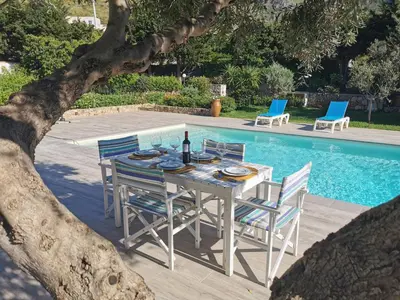 a table and chairs next to a swimming pool at VILLA HIBISCUS in Castellammare del Golfo