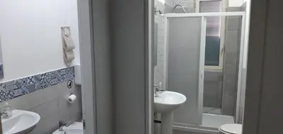 a bathroom with a sink and a toilet and a shower at Manzoni rooms in Palermo