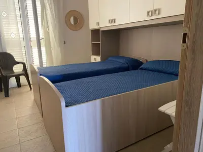 a bedroom with a large bed with blue pillows at Villa GLORIA intero alloggio sulla spiaggia 8 posti letto 15 minuti da Palermo e 35 da Cefalu in Casteldaccia